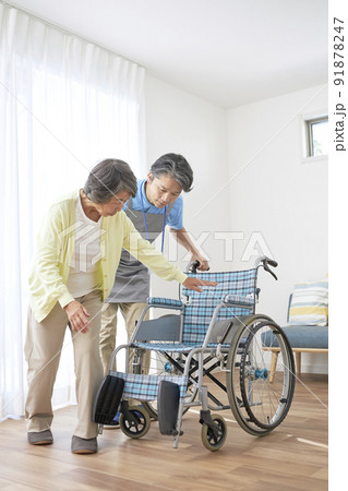 車椅子に座るシニアの女性とミドル男性の介護スタッフ 車椅子に座るシニアの女性とミドル男性の介護スタッフ 91878247