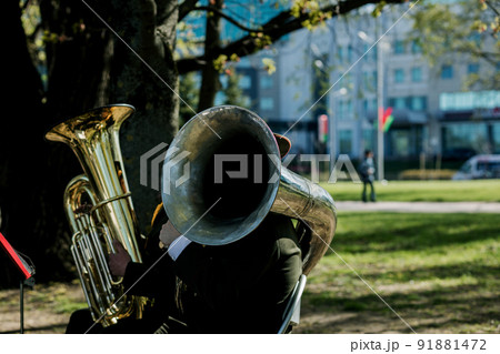 musician playing tuba outdoors. 91881472