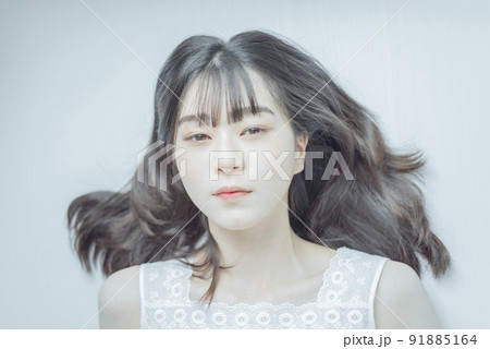 白い部屋で寝そべるセミロングの若い女性 91885164