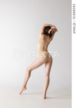 Studio shot of fit adorable woman in comfortable cotton underwear isolated over grey studio background Studio shot of fit adorable woman in comfortable cotton underwear isolated over grey studio background 91886083