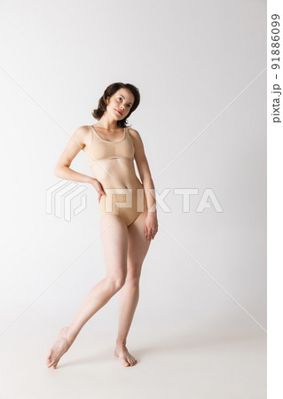 Portrait of young beautiful slim girl in underwear posing isolated over gray studio background. Wellness, wellbeing, fitness, fashion concept. 91886099