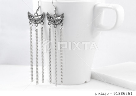 白いカップにぶら下がっているシルバーイヤリング 白いカップにぶら下がっているシルバーイヤリング 91886261