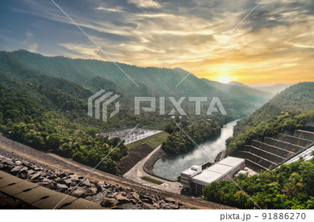 Large Hydro Electricity Dam Power plant with mountain and sunset in background for renewable energy concept. 91886270