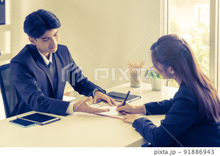 Business man is inviting Business woman to sign contract document agreement on the table. 91886943