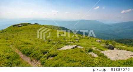 trail down the grassy hill. stones on the green hillside meadow. summer vacation in mountains. sunny afternoon weather with fluffy clouds on the sky 91887076