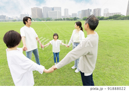 手を繋ぎ輪を作る三世代家族 91888022
