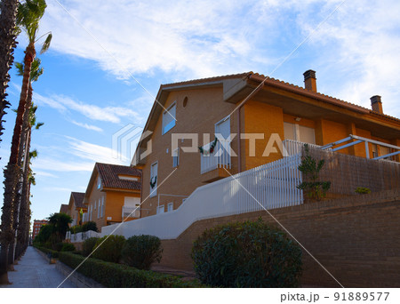 Brick house with palm trees in yard on street. Home with apartments at Alboraia, Patacona beach Brick house with palm trees in yard on street. Home with apartments at Alboraia, Patacona beach 91889577