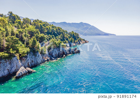 Picturesque sea Adriatic coast of Montenegro. Turquoise Mediteran sea and rocky shore with evergreen coniferous trees. Wonderful summer landscape. Drone 91891174