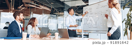 Asian man and woman conducts meeting for employees near a flipchart and explains the work strategy 91891642