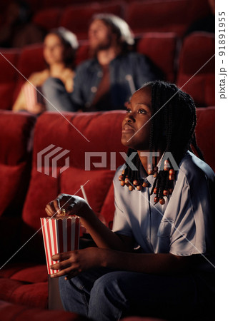 Woman enjoying movie in the cinema Woman enjoying movie in the cinema 91891955