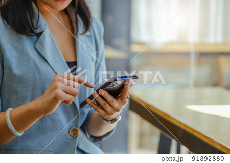 Asian women using smartphone mobile in capital planning to increase company profits. 91892880