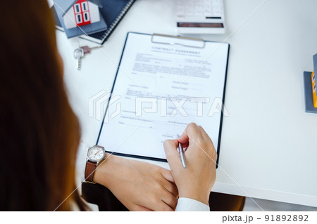 Guarantee, Mortgage, agreement, contract, Signing, Male client holding pen to reading agreement document to sign land loan with real estate agent or bank officer Guarantee, Mortgage, agreement, contract, Signing, Male client holding pen to reading agreement document to sign land loan with real estate agent or bank officer 91892892