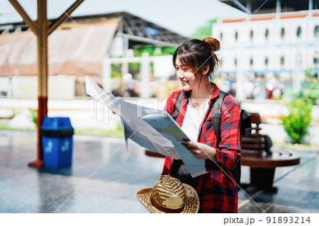 summer, relax, vacation, travel, portrait of a cute Asian girl looking at a map to plan a trip while waiting at the train station summer, relax, vacation, travel, portrait of a cute Asian girl looking at a map to plan a trip while waiting at the train station 91893214