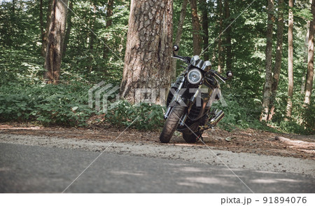 Black road bike on the roadside of a forest road, no people Black road bike on the roadside of a forest road, no people 91894076
