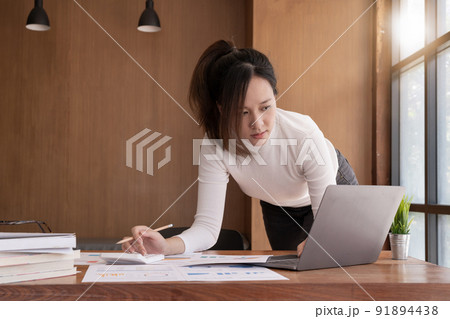 accountant, Auditor, Self-Employed, Finance and Investment, tax calculation and budget, Portrait of Asian female entrepreneur using a calculator to calculate. Company business results document 91894438