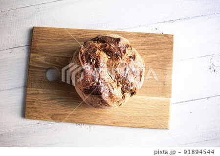 Round bread close-up on brown desk. Freshly baked sourdough bread with a golden crust. Baker shop context with delicious bread. Round bread close-up on brown desk. Freshly baked sourdough bread with a golden crust. Baker shop context with delicious bread. 91894544