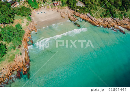 Beach, stones and transparent ocean in Brazil. Aerial view of tropical beach in Florianopolis Beach, stones and transparent ocean in Brazil. Aerial view of tropical beach in Florianopolis 91895445