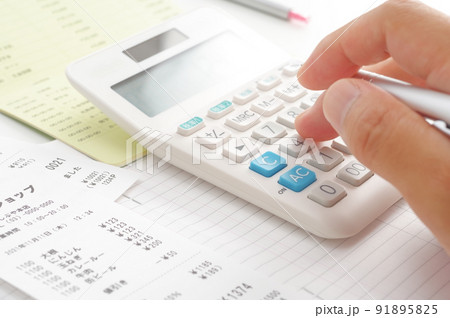 電卓で食費の計算をする人の手元 電卓で食費の計算をする人の手元 91895825