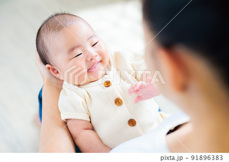 ママの膝の上でのふれあい 生後2ヶ月の笑顔の赤ちゃん ママの膝の上でのふれあい 生後2ヶ月の笑顔の赤ちゃん 91896383