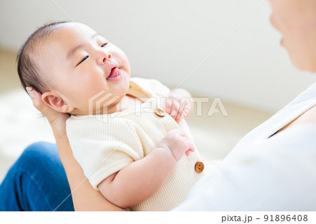 ママの膝の上でのふれあい　舌を出す生後2ヶ月の元気な赤ちゃん 91896408