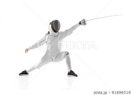 Young girl, beginner fencer in fencing costume and mask practicing with rapier isolated on white background. Sport, youth, healthy lifestyle, achievements. 91896519