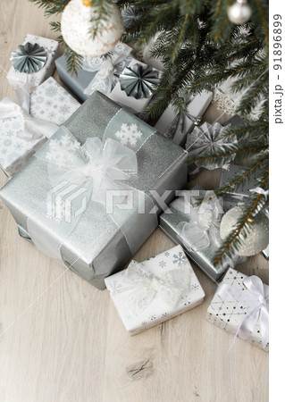 White and silver gift boxes under the Christmas tree 91896899