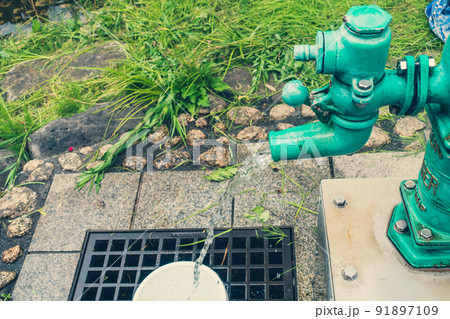 【鯛萬の井戸の脇にあるポンプ】ポンプから湧き出る井戸水【松本市裏町】 91897109