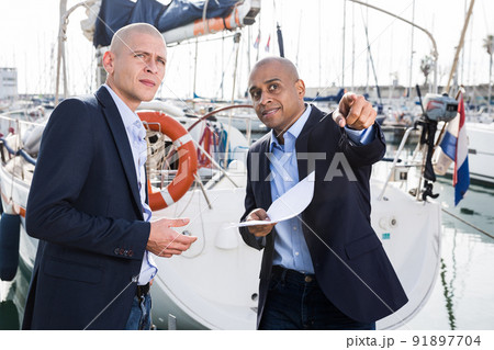 two male businessmen choosing and buying a yacht at seaport two male businessmen choosing and buying a yacht at seaport 91897704