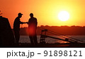 Silhouette of fishermen on the pier at sunset 91898121