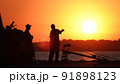 Silhouette of fishermen on the pier at sunset 91898123