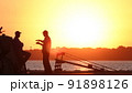 Silhouette of fishermen on the pier at sunset 91898126