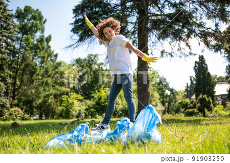 Happy teen jumping having all garbage gathered 91903250