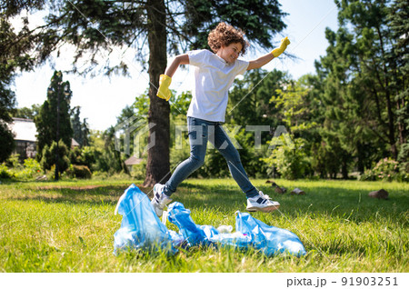 Happy teen jumping having all garbage gathered Happy teen jumping having all garbage gathered 91903251