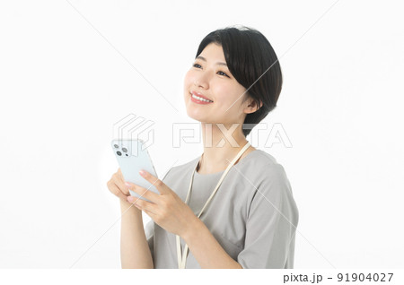 スマホを操作する若いカジュアル衣装の女性エンジニア（白バック） 91904027
