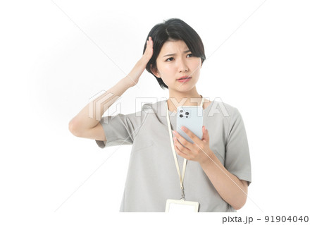 スマホを操作する若いカジュアル衣装の女性エンジニア(白バック) スマホを操作する若いカジュアル衣装の女性エンジニア(白バック) 91904040