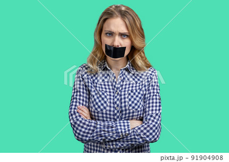 Female protestor with black tape over her mouth demonstrating protest on color background. 91904908