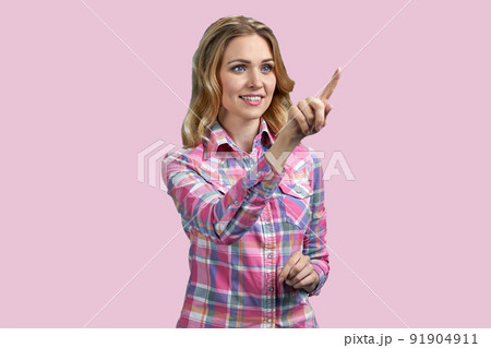 Pretty smiling girl swiping imaginary touch screen on color background. Pretty smiling girl swiping imaginary touch screen on color background. 91904911
