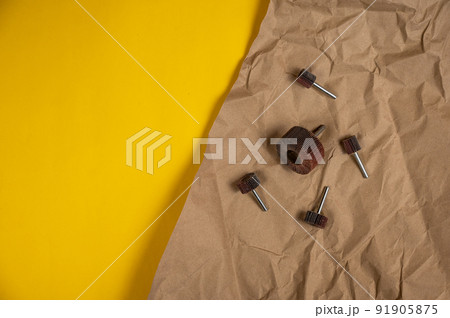 Petal grinding wheels for woodworking as well as deburring surfaces from corrosion, scale or rust. Tool Kit lies on wrapping paper. Crumpled sheet of light brown paper against a yellow background Petal grinding wheels for woodworking as well as deburring surfaces from corrosion, scale or rust. Tool Kit lies on wrapping paper. Crumpled sheet of light brown paper against a yellow background 91905875