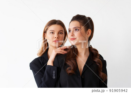 Concept of partnership in business. Two Young businesswoman dressed black formal suit standing studio isolated white background. Concept of partnership in business. Two Young businesswoman dressed black formal suit standing studio isolated white background. 91905942