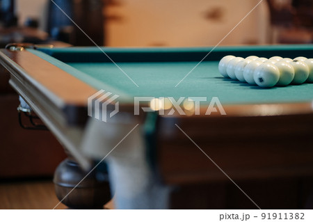 Billiard table with green surface and balls in the billiard club. 91911382