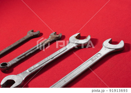 Wrenches, rusty, arranged in ascending order on a red background leaving space for advertising text. Construction tools Wrenches, rusty, arranged in ascending order on a red background leaving space for advertising text. Construction tools 91913693