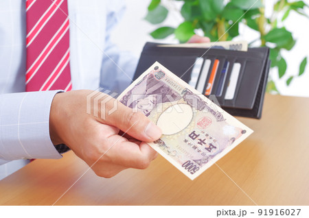 財布から五千円札を出すワイシャツ姿の男性 財布から五千円札を出すワイシャツ姿の男性 91916027
