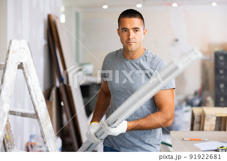 Young man holds an aluminum profile for interior decoration 91922681