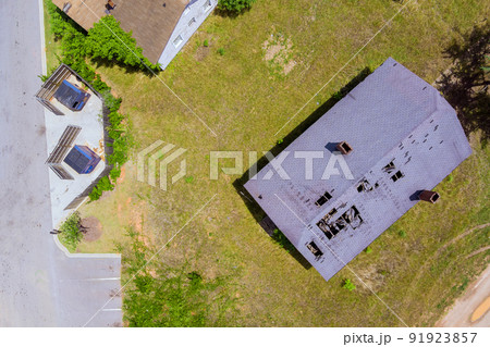 View from the air of roof shingles that have been damaged by high winds and strong storms. View from the air of roof shingles that have been damaged by high winds and strong storms. 91923857