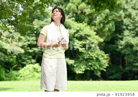 木陰で扇風機を使う女性 木陰で扇風機を使う女性 91923958