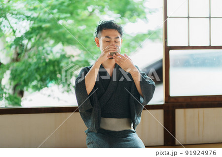 お茶を飲む髭の和服男性 91924976