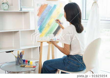 The art concept, Asian female artist using paintbrush to create masterpiece on canvas in art studio 91925054