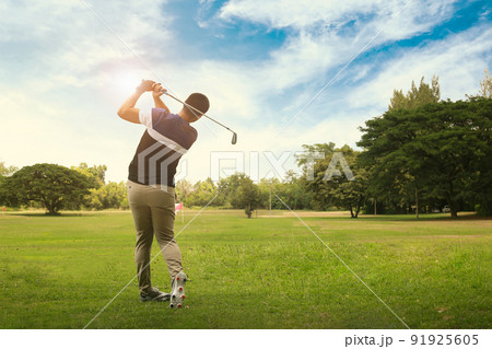 Male golf player with golf club taking a shot. Male golf player with golf club taking a shot. 91925605