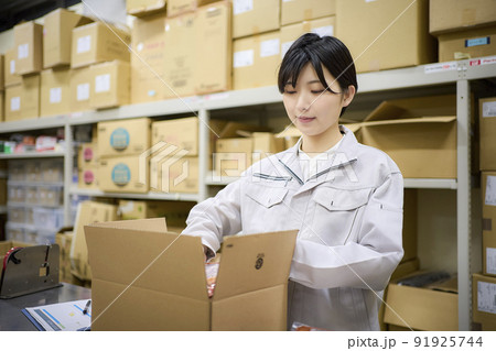 ビジネスシーン　倉庫で出荷作業をする女性 91925744