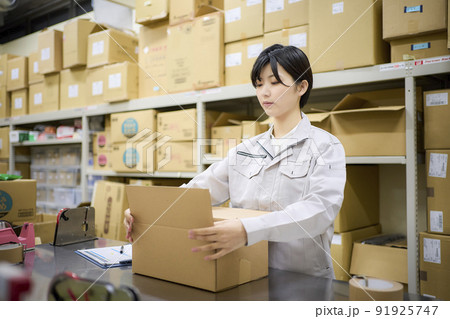 ビジネスシーン　倉庫で出荷作業をする女性 91925747